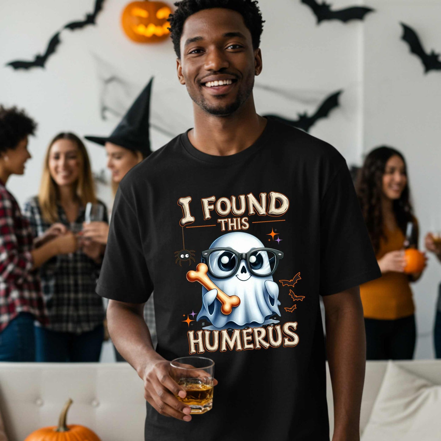 Bone-afide hilarious. This “I Found This Humerus” tee is the ultimate Halloween dad joke wrapped in spooky cute style. Featuring a ghost rocking nerdy glasses and proudly holding a humerus bone like it just cracked itself up—because it did.