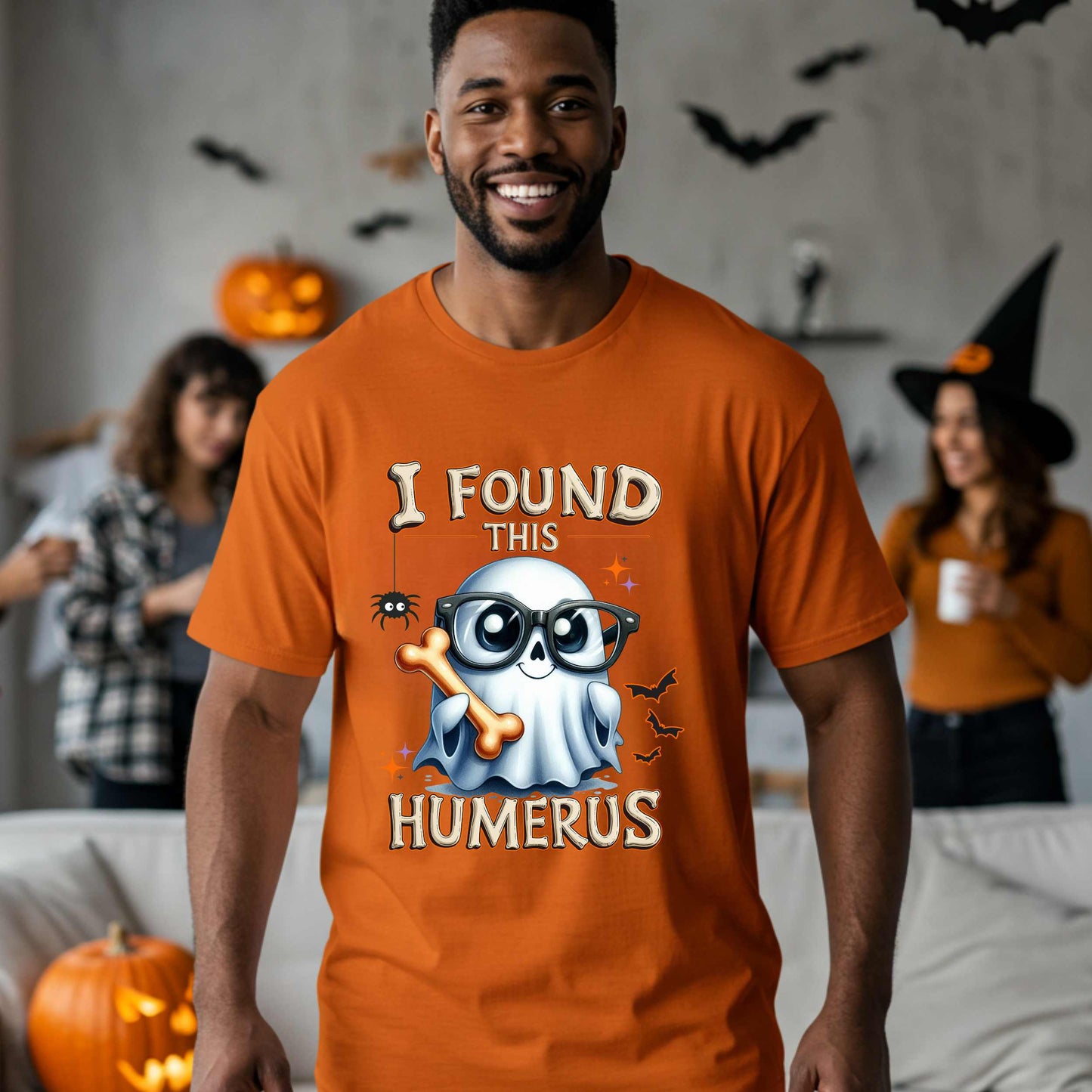 Bone-afide hilarious. This “I Found This Humerus” tee is the ultimate Halloween dad joke wrapped in spooky cute style. Featuring a ghost rocking nerdy glasses and proudly holding a humerus bone like it just cracked itself up—because it did.
