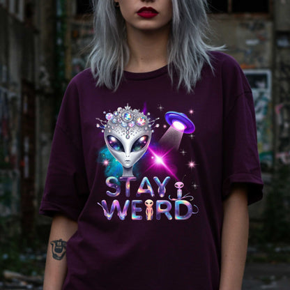 Beam us up, queen—the galaxy’s weirdest and most fabulous fashion icon has entered the orbit. This Stay Weird alien graphic tee is here to remind Earthlings that normal is overrated. Featuring a cosmic glam alien with jeweled headgear and a full-on abduction spotlight moment, this shirt is serving interstellar weirdness with a side of sparkle. 