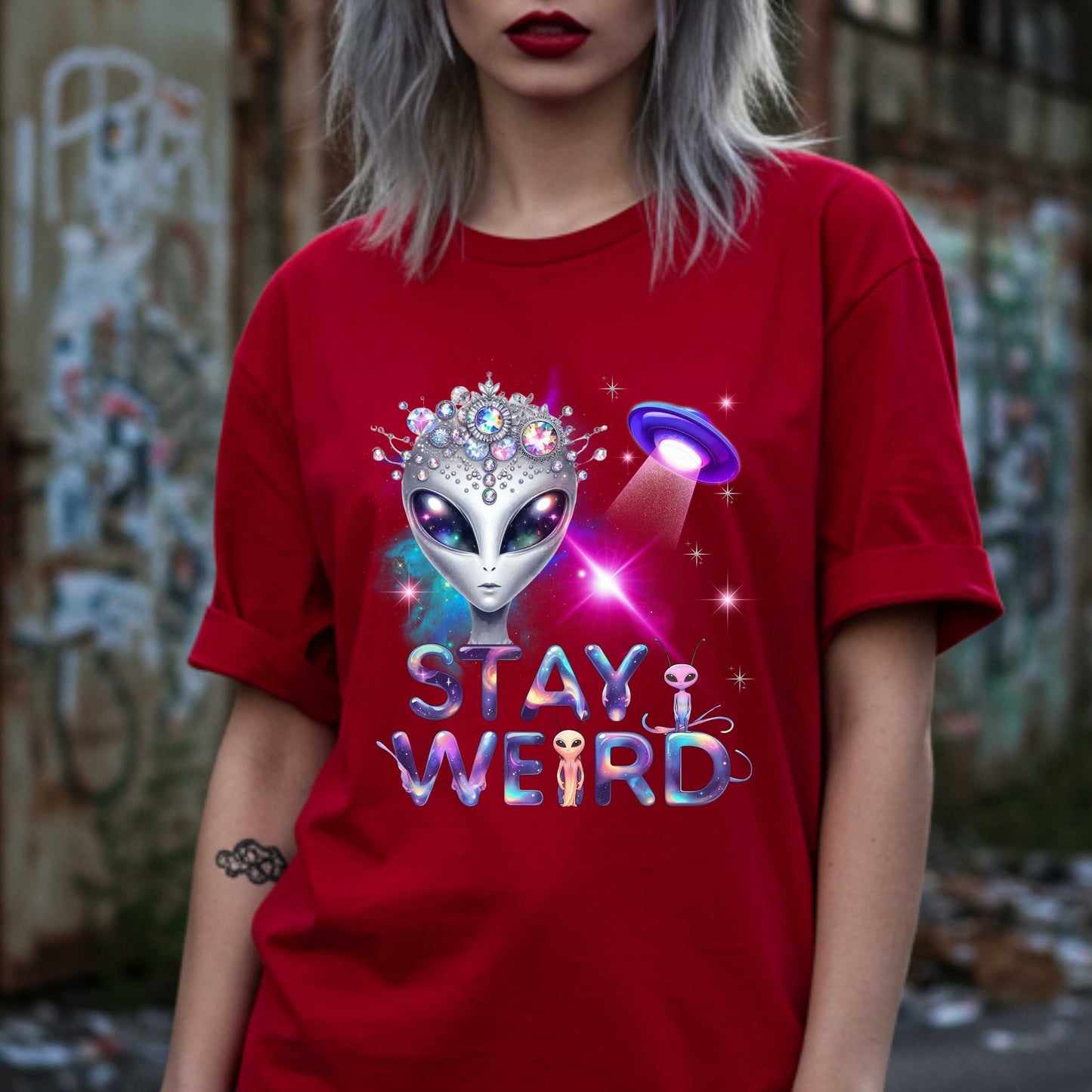 Beam us up, queen—the galaxy’s weirdest and most fabulous fashion icon has entered the orbit. This Stay Weird alien graphic tee is here to remind Earthlings that normal is overrated. Featuring a cosmic glam alien with jeweled headgear and a full-on abduction spotlight moment, this shirt is serving interstellar weirdness with a side of sparkle. 