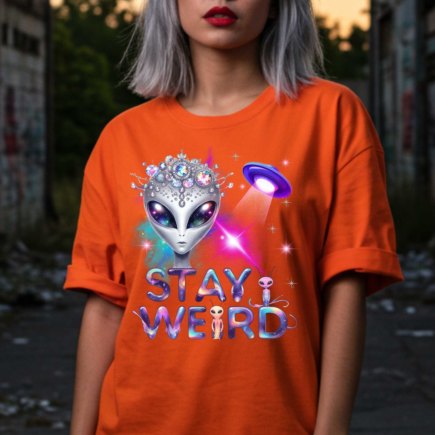 Beam us up, queen—the galaxy’s weirdest and most fabulous fashion icon has entered the orbit. This Stay Weird alien graphic tee is here to remind Earthlings that normal is overrated. Featuring a cosmic glam alien with jeweled headgear and a full-on abduction spotlight moment, this shirt is serving interstellar weirdness with a side of sparkle. 
