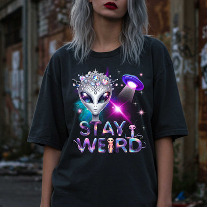 Beam us up, queen—the galaxy’s weirdest and most fabulous fashion icon has entered the orbit. This Stay Weird alien graphic tee is here to remind Earthlings that normal is overrated. Featuring a cosmic glam alien with jeweled headgear and a full-on abduction spotlight moment, this shirt is serving interstellar weirdness with a side of sparkle. 