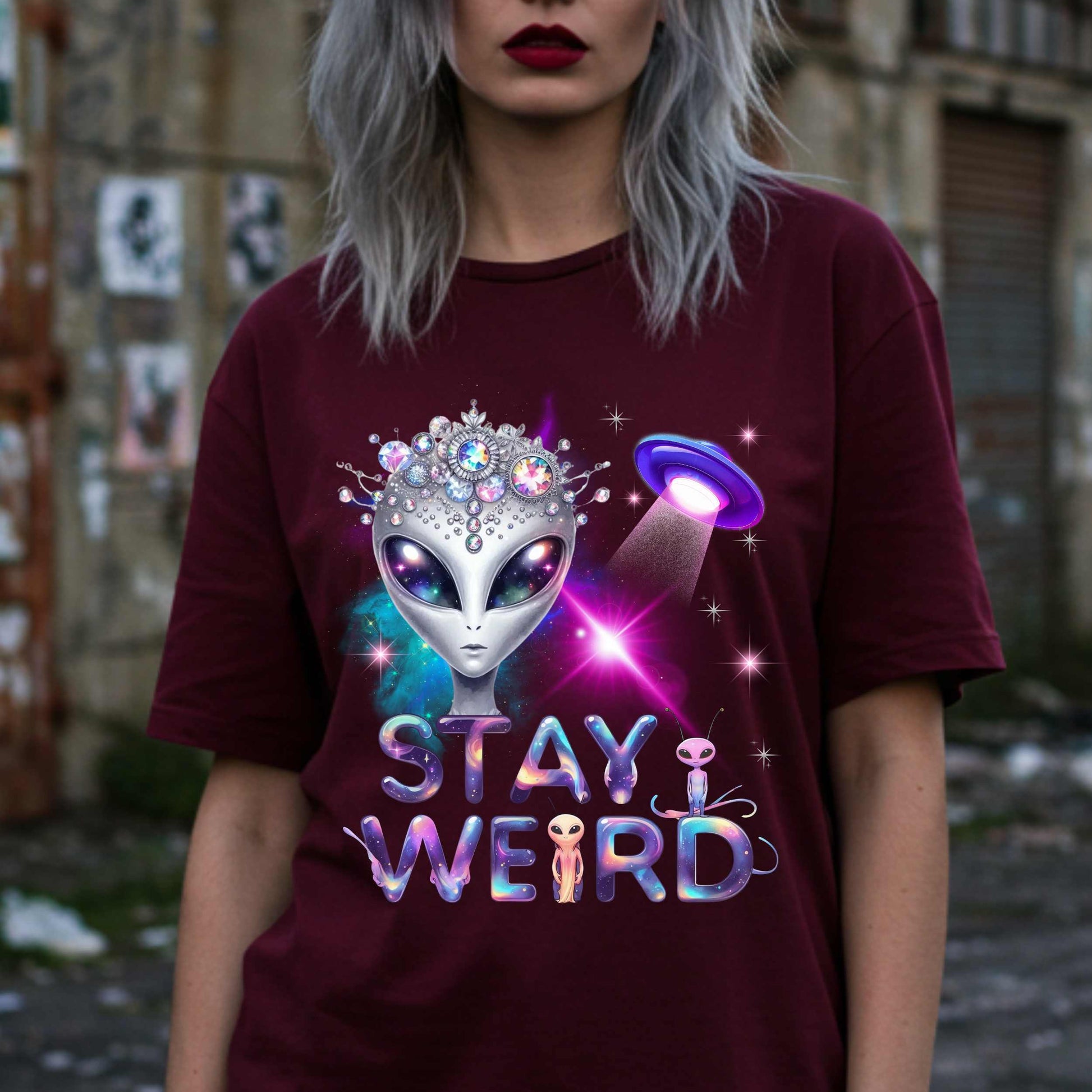 Beam us up, queen—the galaxy’s weirdest and most fabulous fashion icon has entered the orbit. This Stay Weird alien graphic tee is here to remind Earthlings that normal is overrated. Featuring a cosmic glam alien with jeweled headgear and a full-on abduction spotlight moment, this shirt is serving interstellar weirdness with a side of sparkle. 