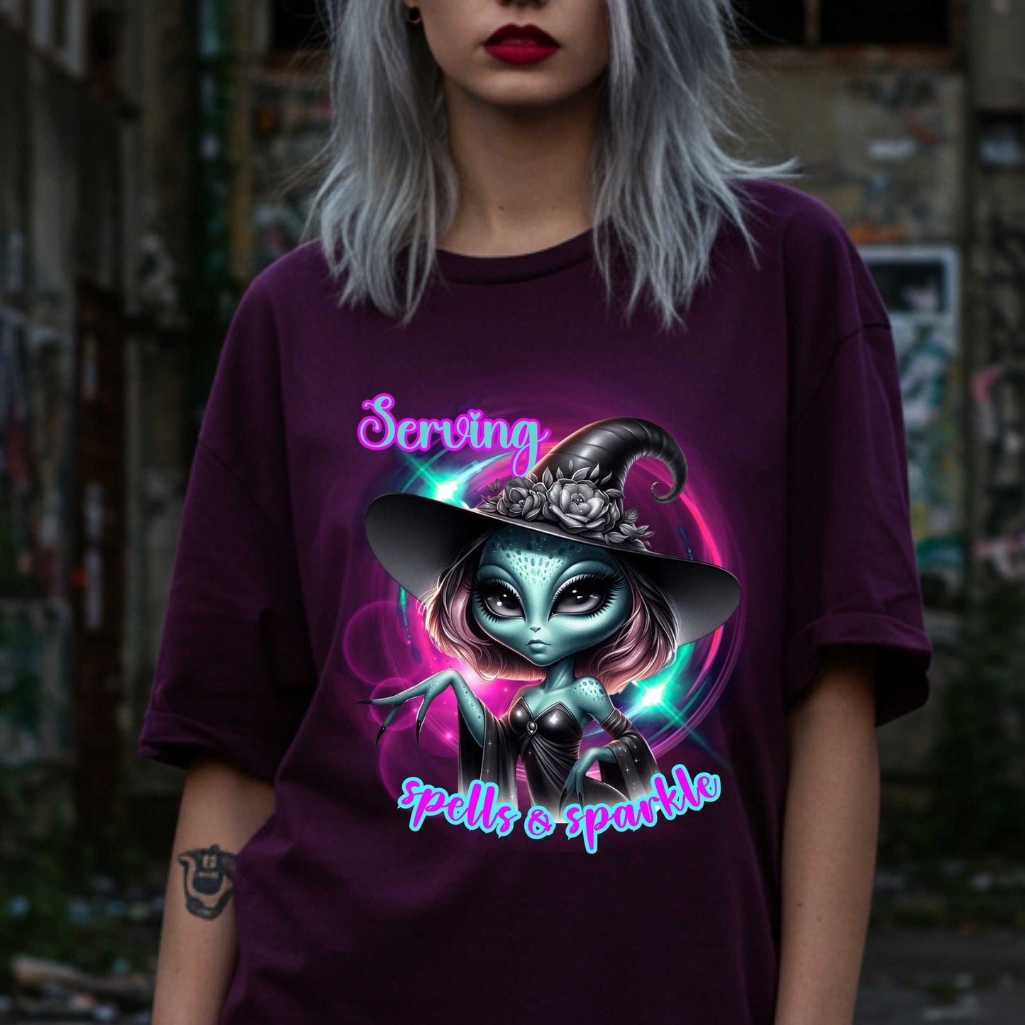 Serving intergalactic glam with a side of sparkle and sass! This glam alien witch graphic tee is perfect for the spooky season and every day you feel too fabulous for Earth. Featuring a fierce extraterrestrial baddie in full witchy slay mode, this shirt says, “I cast spells, but I do it in highlighter and heels.”