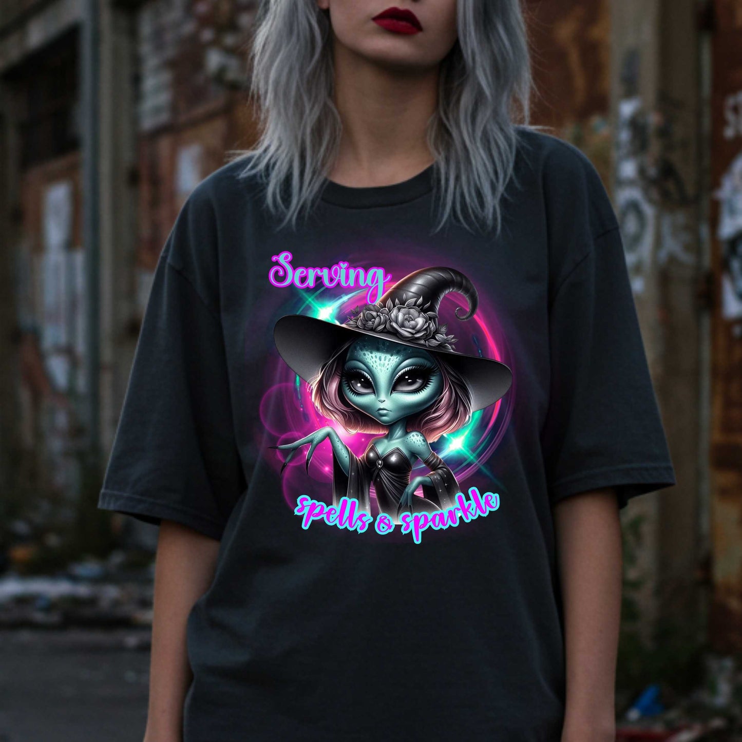 Serving intergalactic glam with a side of sparkle and sass! This glam alien witch graphic tee is perfect for the spooky season and every day you feel too fabulous for Earth. Featuring a fierce extraterrestrial baddie in full witchy slay mode, this shirt says, “I cast spells, but I do it in highlighter and heels.”