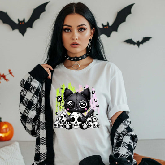 Pastel goth cat Halloween shirt for the spooky babe who wants to be cute, creepy, and slightly unbothered by your opinions. This little stitched-up kitten is sittin’ pretty on a pile of skulls, looking like she just clawed her way out of a haunted Lisa Frank binder. It’s soft, spooky, and a little sinister—just like your mood in October (and let’s be honest, year-round).&nbsp;