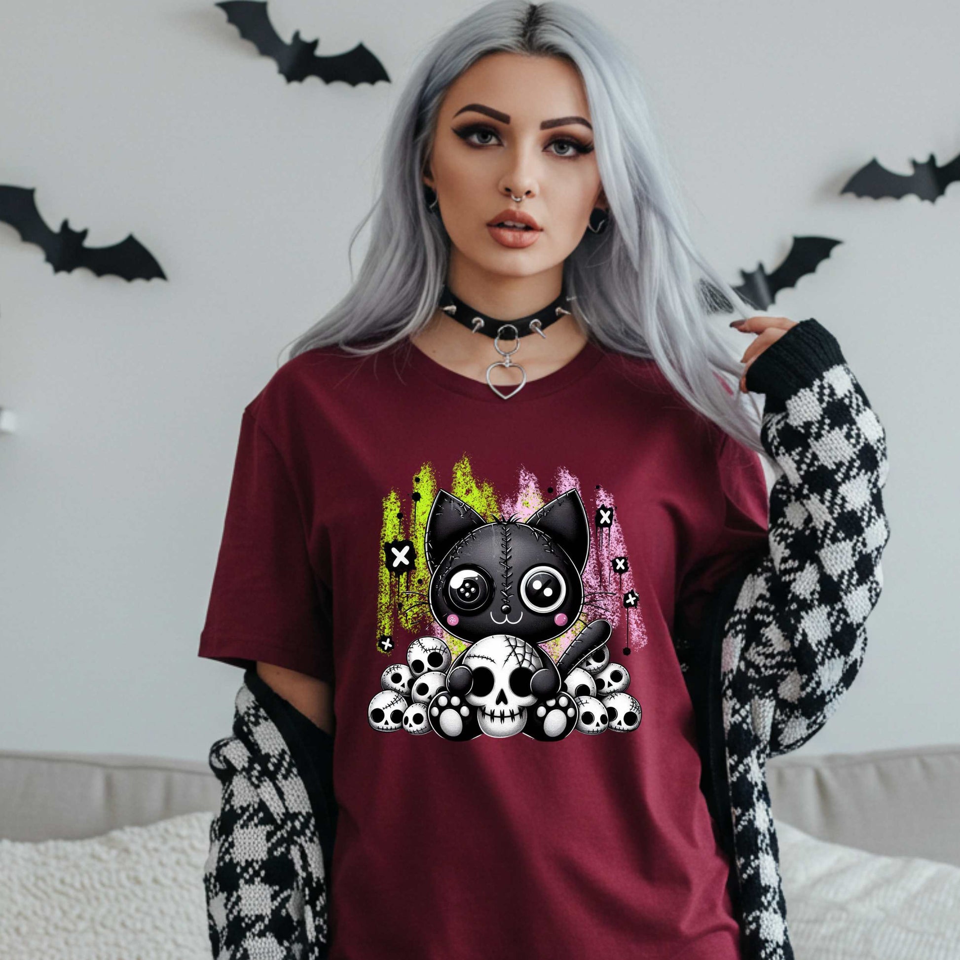 Pastel goth cat Halloween shirt for the spooky babe who wants to be cute, creepy, and slightly unbothered by your opinions. This little stitched-up kitten is sittin’ pretty on a pile of skulls, looking like she just clawed her way out of a haunted Lisa Frank binder. It’s soft, spooky, and a little sinister—just like your mood in October (and let’s be honest, year-round).&nbsp;