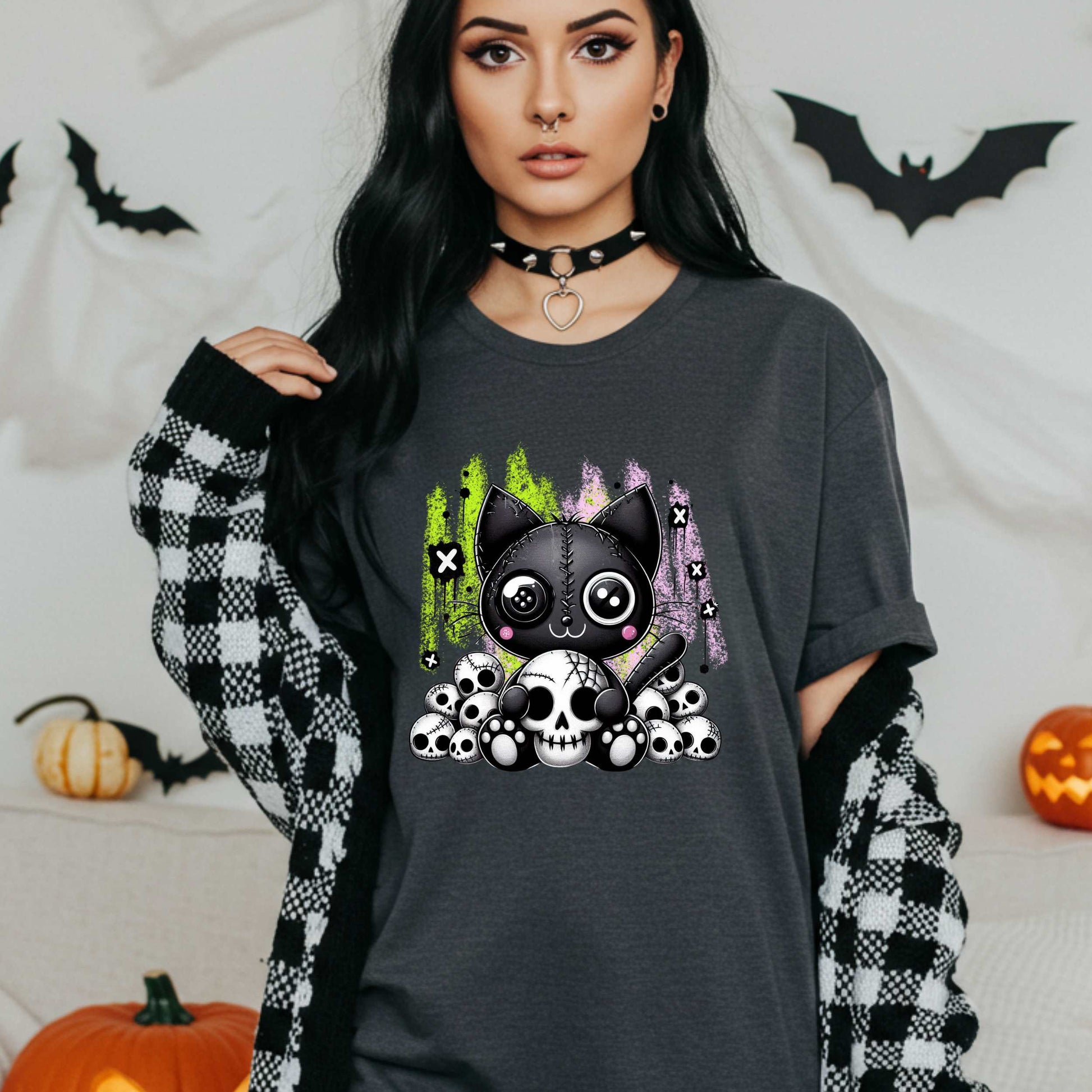 Pastel goth cat Halloween shirt for the spooky babe who wants to be cute, creepy, and slightly unbothered by your opinions. This little stitched-up kitten is sittin’ pretty on a pile of skulls, looking like she just clawed her way out of a haunted Lisa Frank binder. It’s soft, spooky, and a little sinister—just like your mood in October (and let’s be honest, year-round).&nbsp;