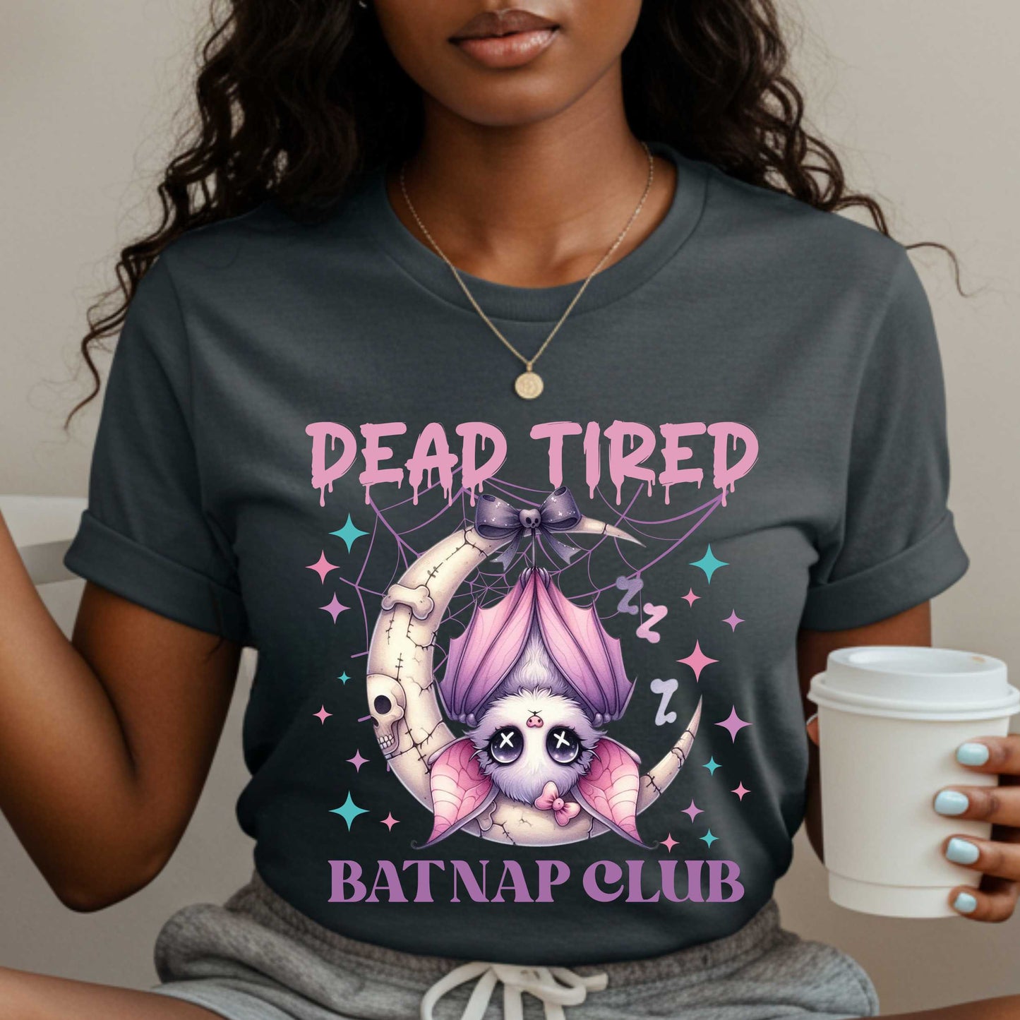 Dead tired and fully over it? Same. Join the Batnap Club with this pastel goth bat Halloween shirt, featuring a sleepy little winged gremlin who’s clearly clocked out. Wrapped in a pink bow and hanging like tomorrow’s problems, this adorable burnout bat is all of us in October (and every Monday). Perfect for spooky naps, haunted errands, or just surviving on caffeine and vibes.&nbsp;