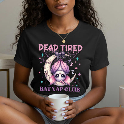 Dead tired and fully over it? Same. Join the Batnap Club with this pastel goth bat Halloween shirt, featuring a sleepy little winged gremlin who’s clearly clocked out. Wrapped in a pink bow and hanging like tomorrow’s problems, this adorable burnout bat is all of us in October (and every Monday). Perfect for spooky naps, haunted errands, or just surviving on caffeine and vibes.&nbsp;