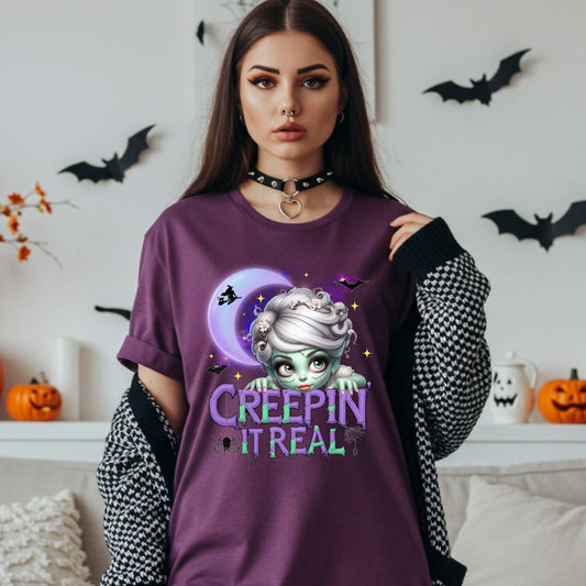 This funny Creepin’ It Real Halloween shirt is the perfect spooky tee for keeping it creepy, cute, and a little unhinged all spooky season long. Who needs subtle when you can be bold, undead, and sarcastically stylish? Whether you're haunting the living room or creeping through the Halloween party like a glam ghoul, this cute creepy graphic tee is a whole October mood. 