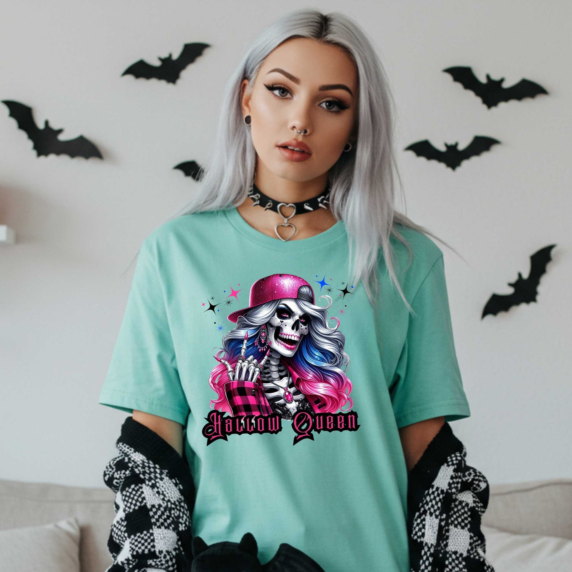 Featuring a glam skeleton with flowing pastel hair, pink flannel, and a glittery hat, she’s clearly been slaying the afterlife runway since 1802. Perfect for the girls who haunt with heels, sparkle under the moonlight, and don’t have time for basic. Serve full-body sass while you sashay through spooky season.