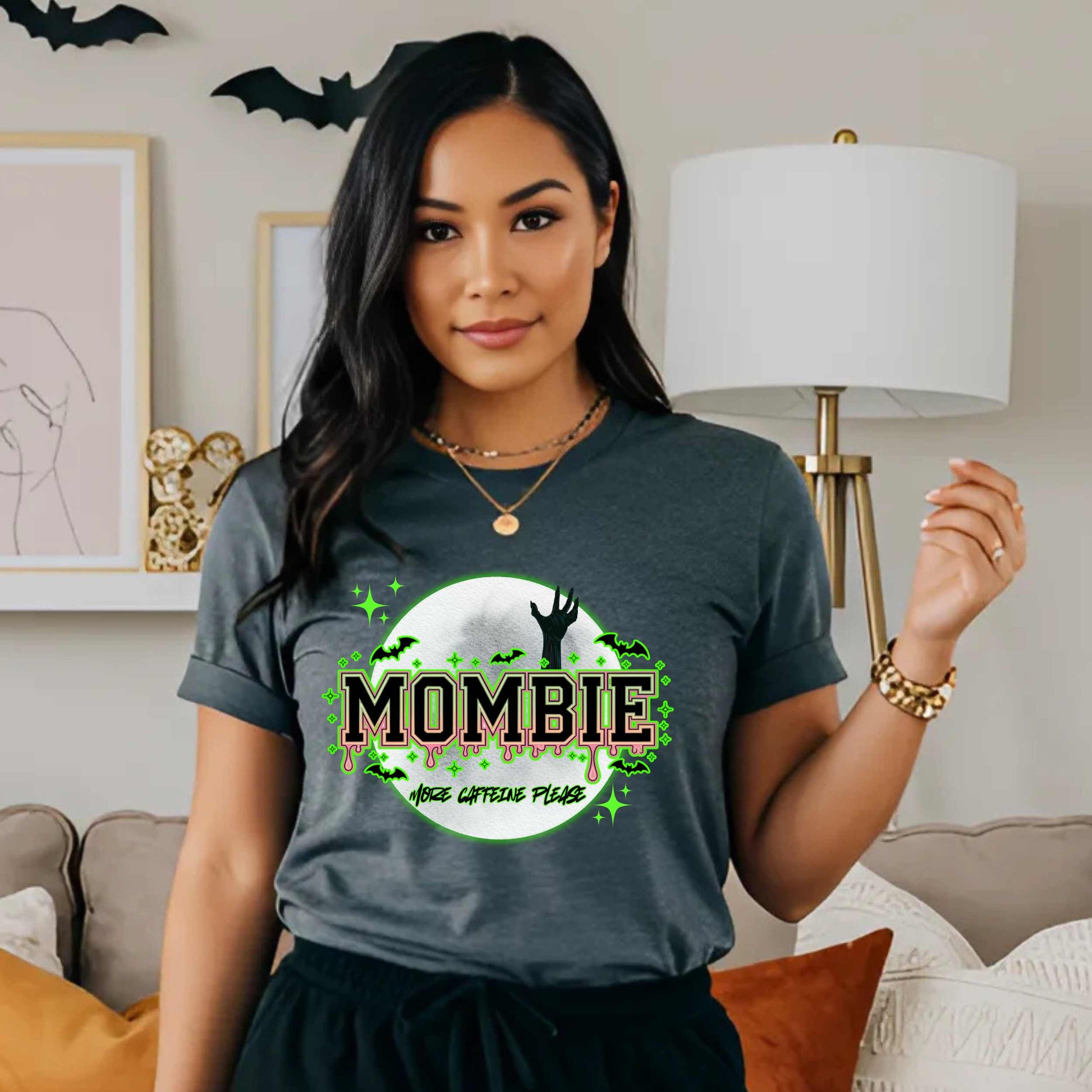 This hilariously relatable Halloween tee is perfect for the spooky season (and honestly, every Monday). With a ghoulish hand rising for coffee and the plea “More Caffeine Please,” this shirt speaks fluent mom and monster. Whether you're chasing kids or caffeine, this tee is your ultimate uniform for the undead-but-still-doing-it life.