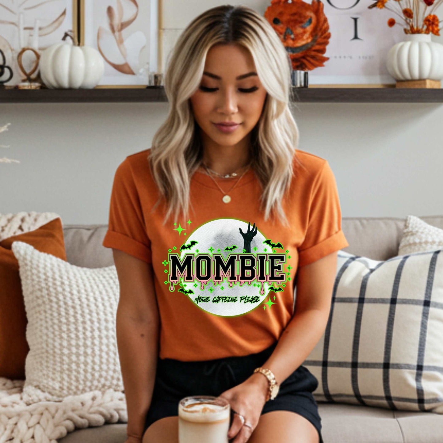 This hilariously relatable Halloween tee is perfect for the spooky season (and honestly, every Monday). With a ghoulish hand rising for coffee and the plea “More Caffeine Please,” this shirt speaks fluent mom and monster. Whether you're chasing kids or caffeine, this tee is your ultimate uniform for the undead-but-still-doing-it life.