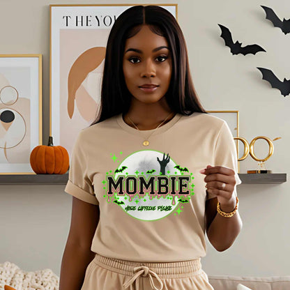 This hilariously relatable Halloween tee is perfect for the spooky season (and honestly, every Monday). With a ghoulish hand rising for coffee and the plea “More Caffeine Please,” this shirt speaks fluent mom and monster. Whether you're chasing kids or caffeine, this tee is your ultimate uniform for the undead-but-still-doing-it life.