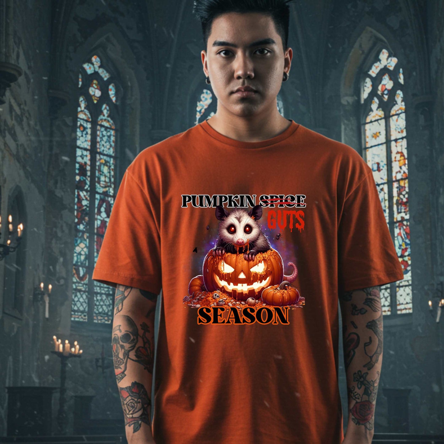 his shirt is for the spooky souls who prefer chaos over cinnamon and guts over glitter. Featuring a bug-eyed opossum with serial killer energy and a face full of pumpkin guts, this tee is perfect for anyone who thinks PSLs are for basic witches and wants to haunt fall fashion in the most unhinged way possible.