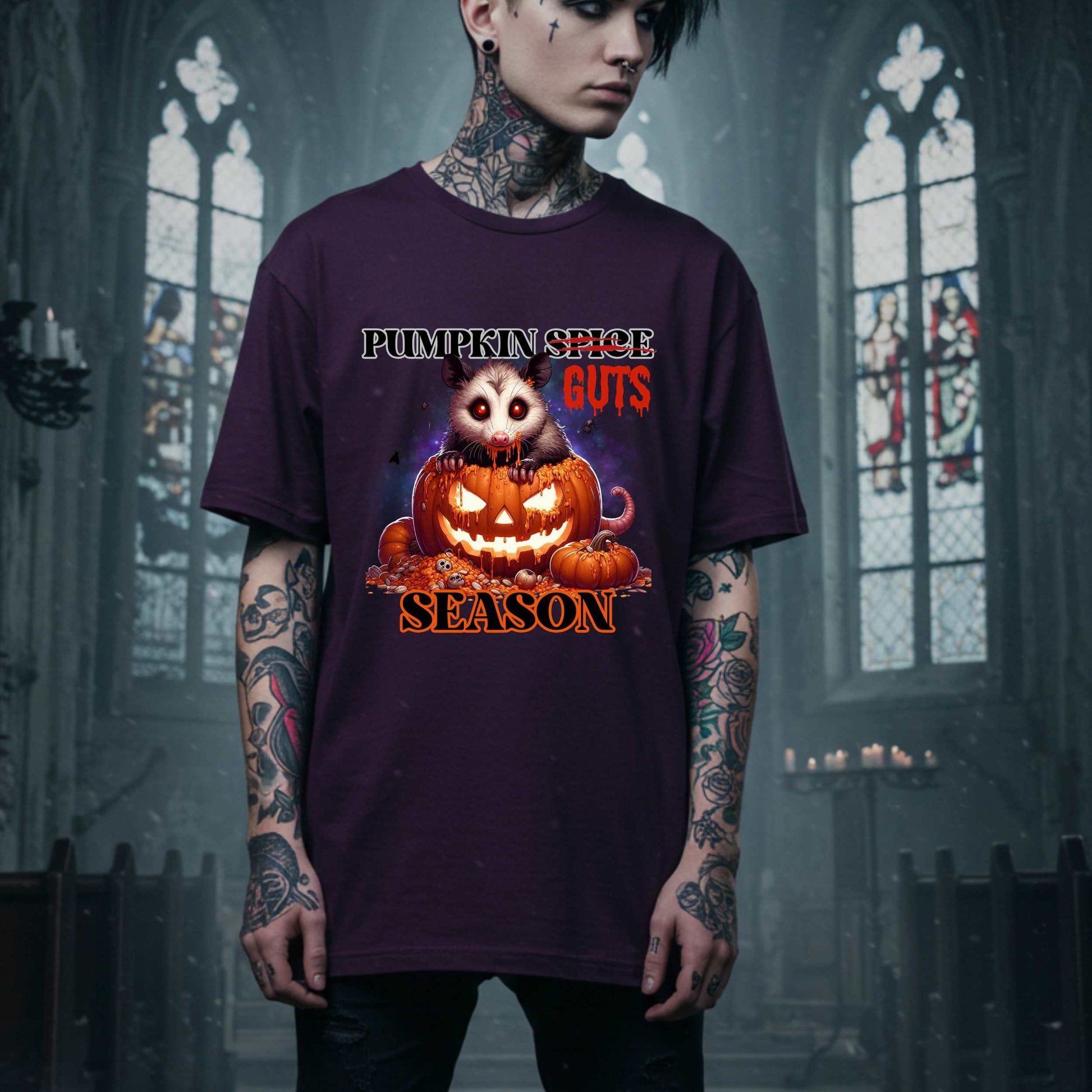 his shirt is for the spooky souls who prefer chaos over cinnamon and guts over glitter. Featuring a bug-eyed opossum with serial killer energy and a face full of pumpkin guts, this tee is perfect for anyone who thinks PSLs are for basic witches and wants to haunt fall fashion in the most unhinged way possible.