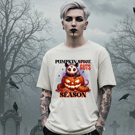 his shirt is for the spooky souls who prefer chaos over cinnamon and guts over glitter. Featuring a bug-eyed opossum with serial killer energy and a face full of pumpkin guts, this tee is perfect for anyone who thinks PSLs are for basic witches and wants to haunt fall fashion in the most unhinged way possible.