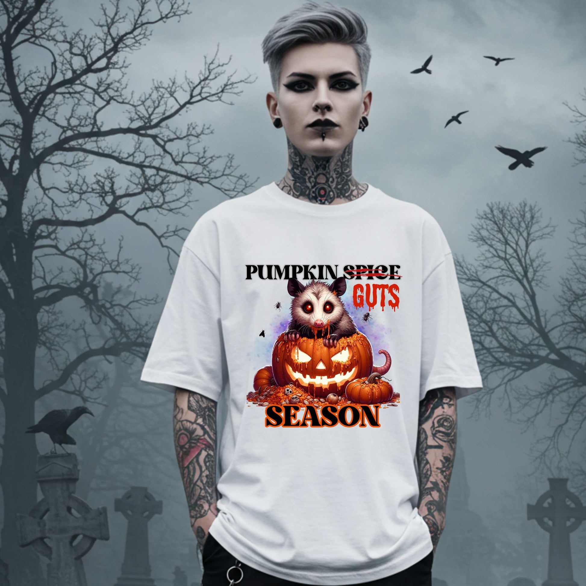 his shirt is for the spooky souls who prefer chaos over cinnamon and guts over glitter. Featuring a bug-eyed opossum with serial killer energy and a face full of pumpkin guts, this tee is perfect for anyone who thinks PSLs are for basic witches and wants to haunt fall fashion in the most unhinged way possible.