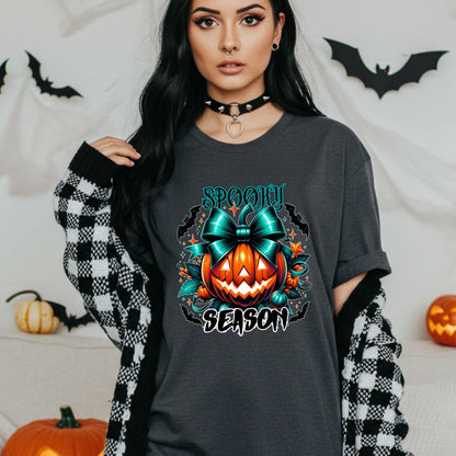 Step aside basic witches, this pumpkin came to SLAY. Our Spooky Season tee brings the perfect mix of creepy and cute—featuring a fierce jack-o’-lantern crowned with a bold teal bow and surrounded by gothic glam accents.