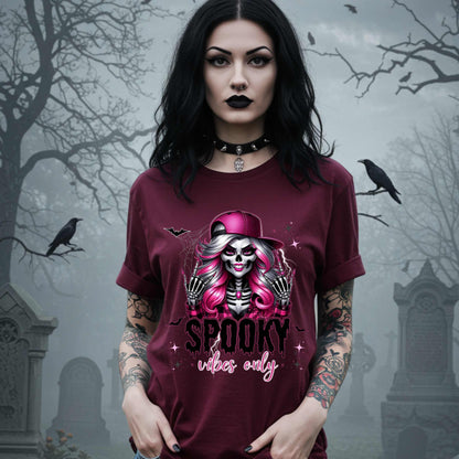  This Spooky Vibes Only tee is the perfect blend of glam and goth, featuring a pink-haired skeleton baddie with nails sharp enough to slash a pumpkin and a hat tilted like she’s haunting the runway. This shirt is for the ghouls who don’t do basic. 
