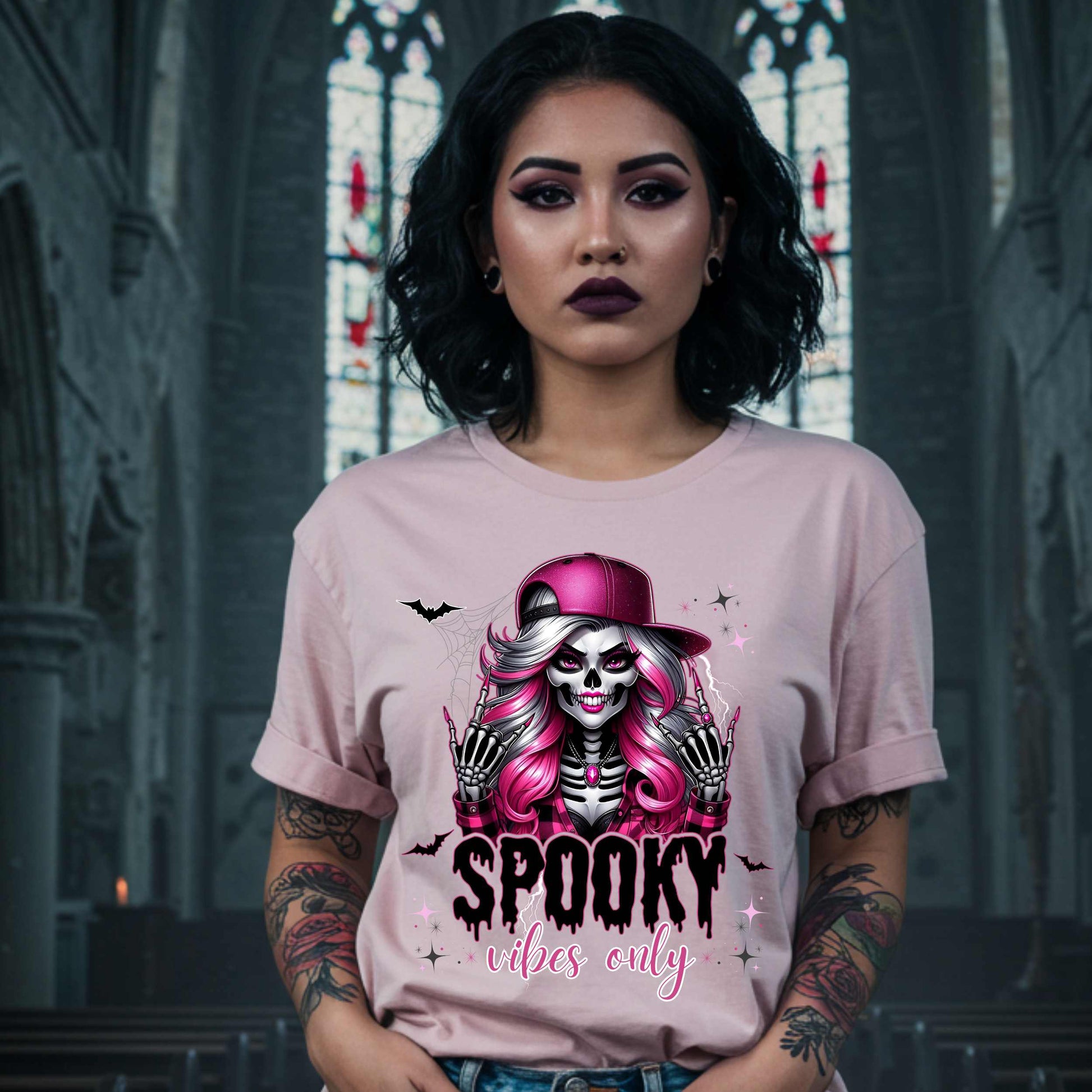  This Spooky Vibes Only tee is the perfect blend of glam and goth, featuring a pink-haired skeleton baddie with nails sharp enough to slash a pumpkin and a hat tilted like she’s haunting the runway. This shirt is for the ghouls who don’t do basic. 