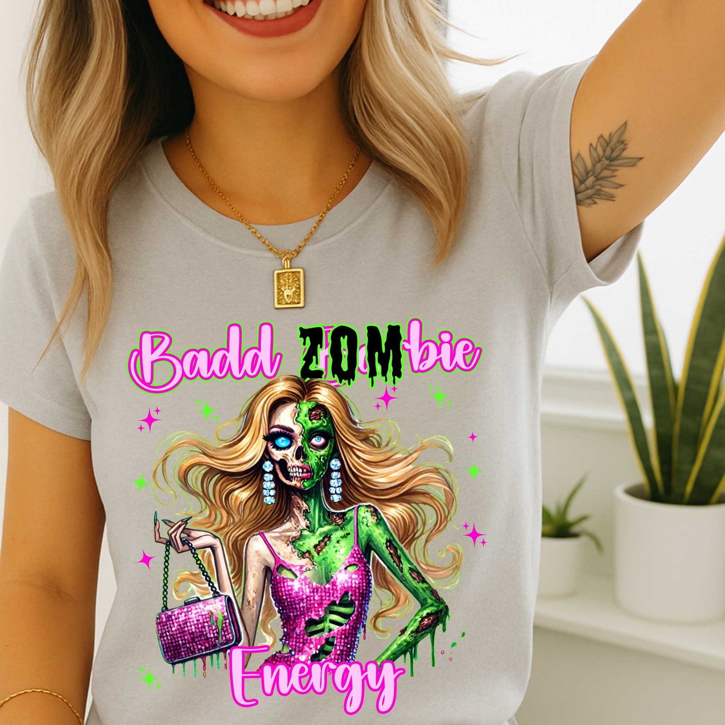 Brains, but make it fashion. This Badd Zombie Energy tee is for the girls who slay… even in the afterlife. Rocking a glittery pink dress, designer handbag, and enough undead glam to raise the dead, this zombie babe is dripping in sass (and maybe a little ooze).